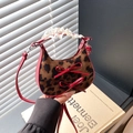 Leopard print half-moon bag with red bows and lace handle held by a hand - Red Leopard