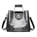 Graue Handtasche mit Schlangenmuster, schwarzen Lackdetails und rundem Metallgriff - Schwarz