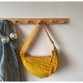 Detail of yellow nylon crescent bag featuring woven zipper pulls and wide shoulder strap - Green