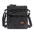 Detalle de bolso bandolera de mezclilla lavada con múltiples cremalleras y etiqueta de cuero - Negro