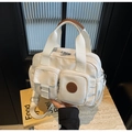 Vue détaillée du sac en nylon imperméable avec poches et logo en cuir élégant - Blanc Cassé
