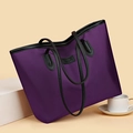 Bolso tote minimalista morado de gran capacidad con asas de cuero negro en fondo cálido - Morado