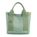 Borsa tote in tela verde menta con tasche multiple, manici intrecciati e ciondolo tondo - Verde