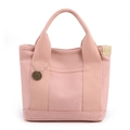 Borsa tote in tela rosa con cinghie rinforzate e ciondolo logo su uno sfondo bianco - Rosa