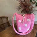 Close-up of pink plush bucket bag with white flower embroidery and drawstring detail - Pink