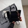 Borsa tote nera minimalista con texture a contrasto e ciondolo etnico con nappe - nero con ciondolo