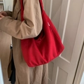 Minimalist red oversized hobo shoulder bag in soft felt texture worn with a stylish coat - Red