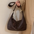 Sac hobo croissant en daim marron rétro avec pompon à franges porté par un mannequin - Marron