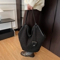 Black large capacity plush tote bag with leather straps worn by model in a cozy setting - Black