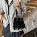 Détail d'un sac à main noir vintage avec des rivets argentés et de longues franges déco - Noir