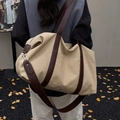 Borsa tote minimalista in tela beige con cinturini in pelle marrone in una vista all'aperto - Cachi