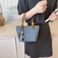 Blue denim style handbag with brown leather handles and decorative chocolate charm - Blue