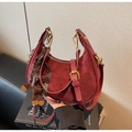 Dettaglio della borsa hobo bordeaux con texture patchwork e ciondolo a forma di orso - Rosso Vino Con Pendente