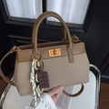 Borsa retrò in tela e pelle marrone con ciondolo a catena su sedia bianca - Albicocca
