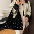 Black studded hobo bag in suede finish styled with a beige trench coat for a chic look - Black