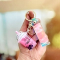 Roze kattenmelkthee sleutelhanger met glitterband en goudkleurige bel - Roze