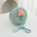 Detailed macro view of mint blue woven straw bag with handmade floral applique design - Diameter 15cm / Green Round Bag with Pink Flower