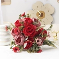 Detailed view of red and pink artificial peony bouquet with green leaves and berries - Red