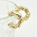 Detail of chunky gold-plated C-shaped earrings with unique molten lava textured finish - Hammered C-Hoop Gold
