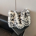 Borsa tote in peluche a macchie bianche e nere su sedile in pelle nera elegante - Bianco