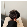 Detailed close-up of glossy black spherical clutch bag with golden chain and mirror finish - Black
