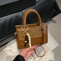 Brown leather crossbody handbag with woven handle and bohemian bead charm accessory - Brown