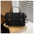 Sac bandoulière noir en cuir et daim avec boucles dorées dans un décor lumineux moderne - Noir
