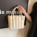 Elegante borsa a mano plissettata color crema con fibbie a sfera e texture morbida - Beige