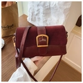 Detailed close-up of a burgundy leather flap bag with vintage gold buckle and long strap - Red