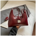 Detail der burgunderroten Ledertasche mit silberner Metallschnalle und Tragegriff - Rot