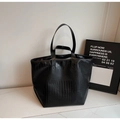 Detail of black crocodile embossed tote bag featuring dual handles for shoulder and hand carry - Black