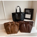 Detailed view of three large crocodile pattern tote bags in black, tan, and dark brown - Brown
