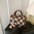 Borsa Boston a scacchi marrone con doppi manici e tracolla larga in un ambiente accogliente - Quadri Marrone