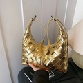 Goldene geflochtene Hobo-Tasche mit Metallic-Textur in einer ästhetischen Innenaufnahme - Gold