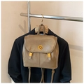 Close-up of a retro backpack with a gold swivel lock and textured khaki faux leather material - Khaki