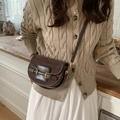 Bolso de hombro marrón oscuro de ante mate con hebillas doradas llevado por modelo en interior - Verde