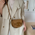 Bolso bandolera retro marrón bicolor con hebillas doradas sobre una gabardina color beige - Marrón