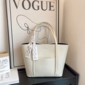 Detail view of beige lychee leather tote bag with a decorative fashion silk scarf on the handle - Off White