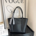 Detail of black pebbled leather tote bag with a decorative check silk scarf on the handle - Black