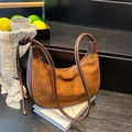 Bolso de hombro media luna en ante marrón con asa anudada sobre libros blancos - Marrón