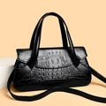 Dettaglio della goffratura a coccodrillo nero su una borsa a mano vintage versatile - Nero
