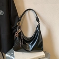 Glossy black leather hobo bag with a brown knot and metal abacus charm on books - Black With Pendant