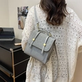 Sac à main carré gris vintage en similicuir avec boucles dorées porté par un modèle - Argent