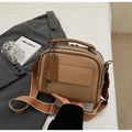 Dettaglio della borsa in pelle martellata kaki con zip multistrato e ampia tracolla in tessuto - Cachi