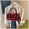 Close-up of deep red leather crossbody bag with mixed smooth and suede textures - Red