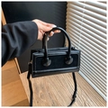 Minimalist black bucket bag in textured leather with top handles and crossbody strap - Black