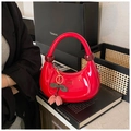 Borsa a spalla a mezzaluna rossa lucida con ciondolo a ciliegia su sfondo sobrio - Rosso
