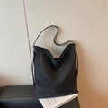 Bolso hobo minimalista de lona negra para mujer sobre un libro de diseño para el diario - Negro
