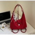 Vista de detalle de mochila roja con lazo y colgante de estrella de plata en mesa - Burdeos