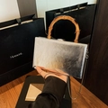Silberne Metallic-Box-Tasche mit Bambusgriff und Schlangenkette, in der Hand gehalten - Silber